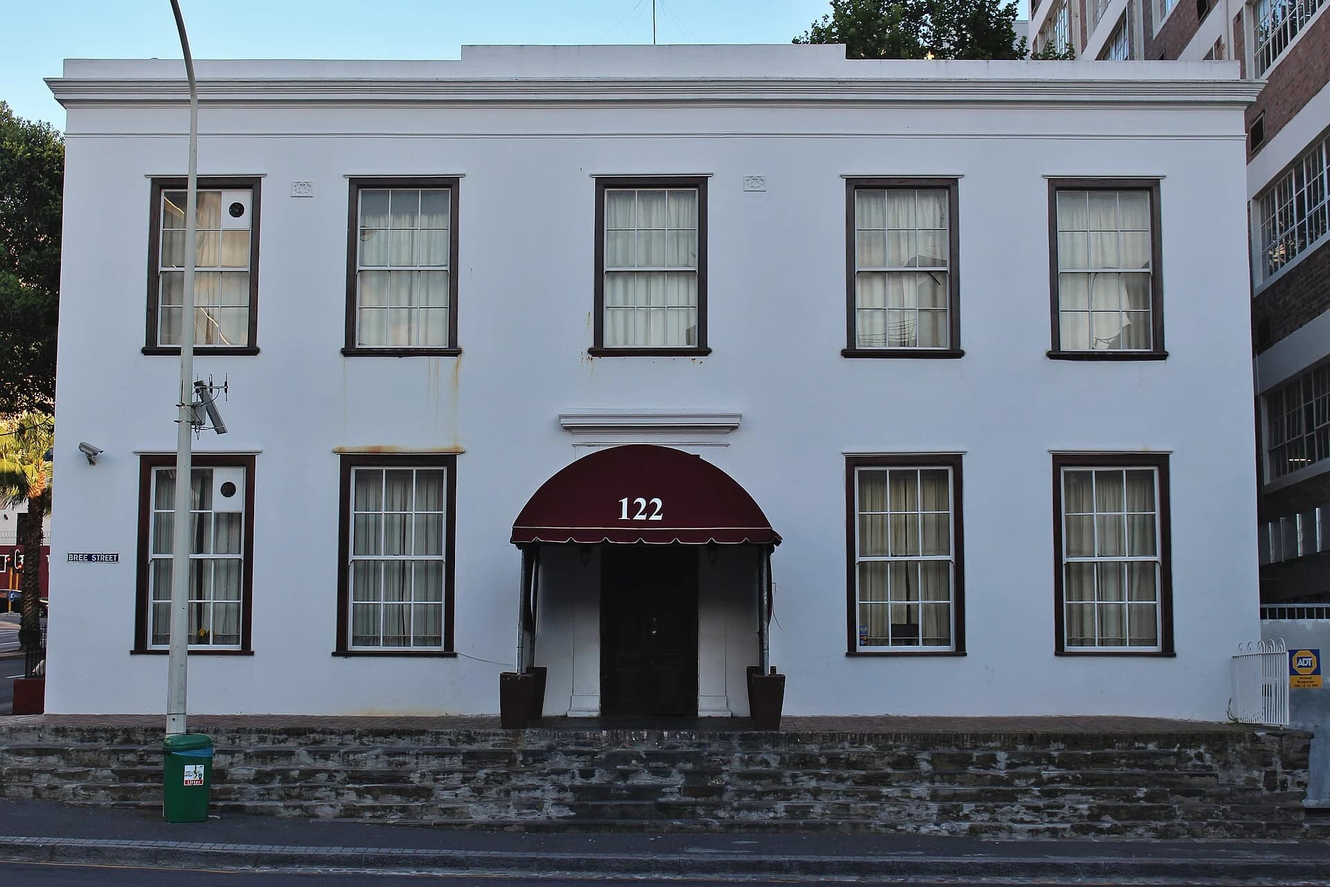 The existing white street façade and entrance at 122 Bree Street in Cape Town.