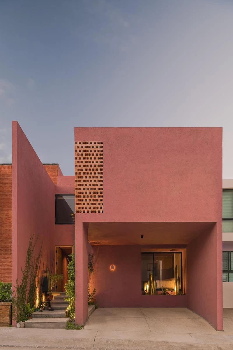 Pink street facade with a recessed entrance and perforated screen · LGM Studio · via v2com