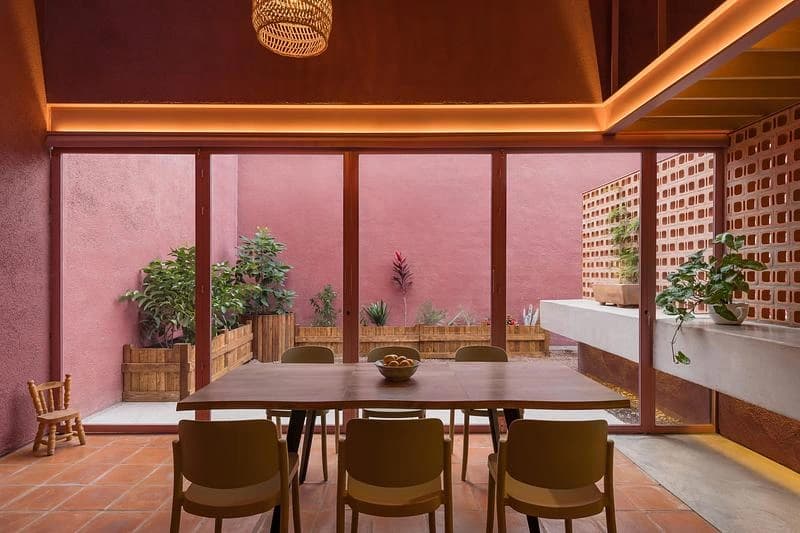 Dining table beside the glazed courtyard and brick lattice · LGM Studio · via v2com