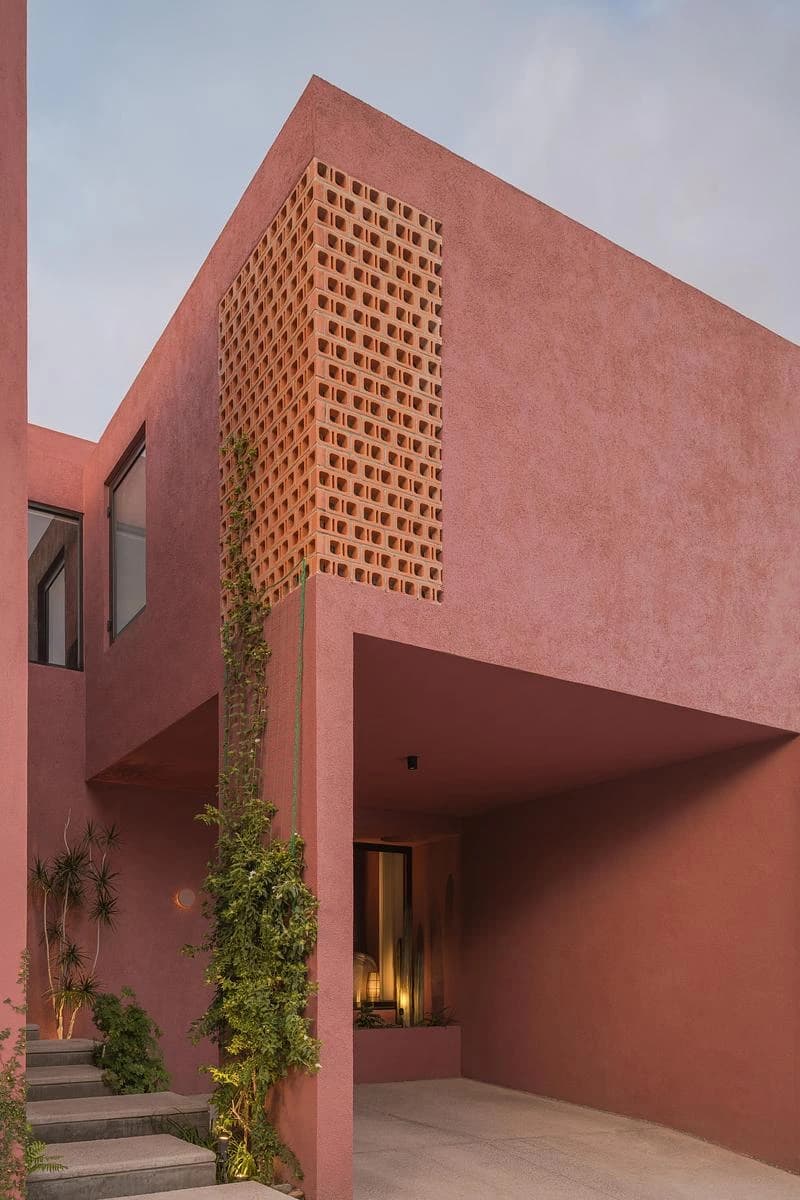 Angled view of the pink facade and yellow-toned lattice · LGM Studio · via v2com