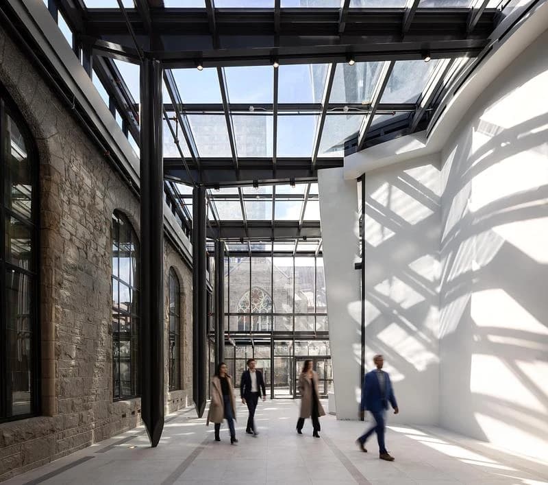 A glazed galleria joins the new Butterfly development with the masonry wall of First Baptist Church.