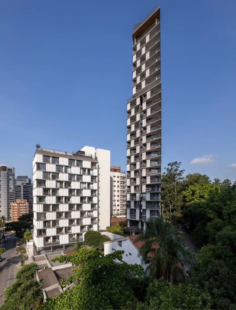 Onze22’s residential towers rise above a planted garden in São Paulo, with balcony edges around the façades.