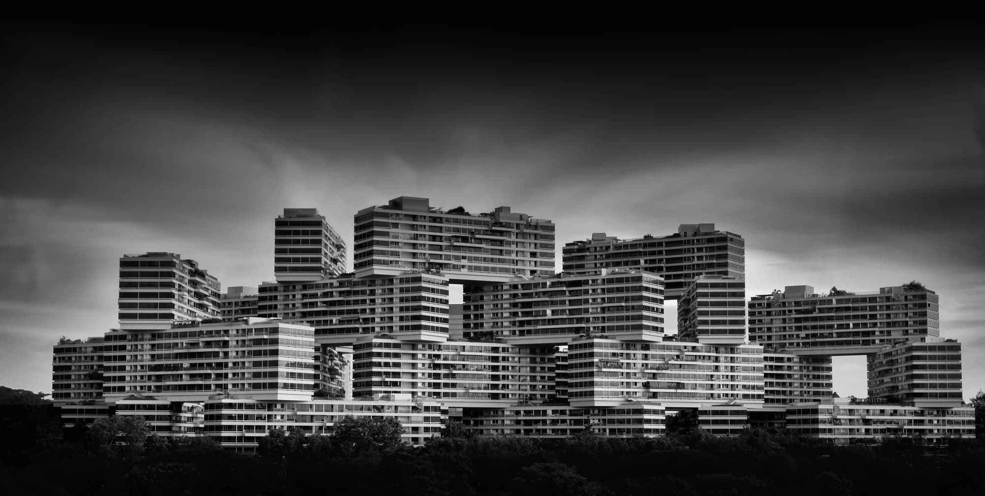 Monochrome photograph of the stacked residential blocks of The Interlace in Singapore.