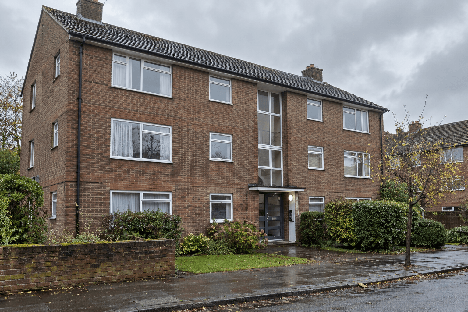 Older low-rise brick flats with a shared entrance and visible rainwater downpipe.
