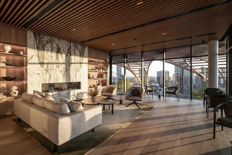Shared lounge at Upper House, with timber ceiling, seating and glazing towards planting.