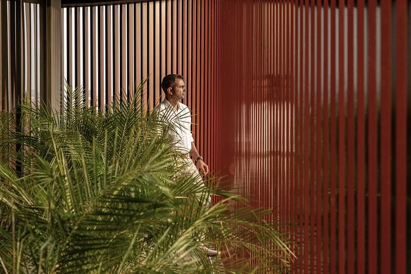 A planted outdoor passage behind the vertical screens · Vinay Panjwani · via v2com