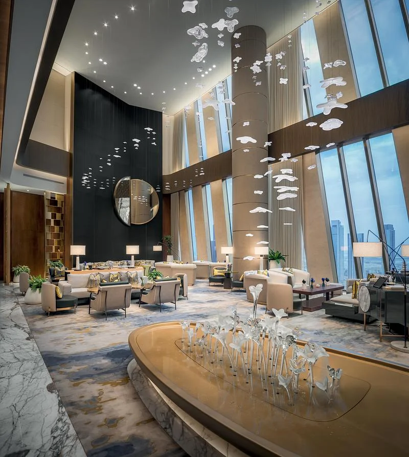 A double-height hotel lounge with suspended bird-like elements · Ahmad Alnaji - SARAB · via v2com