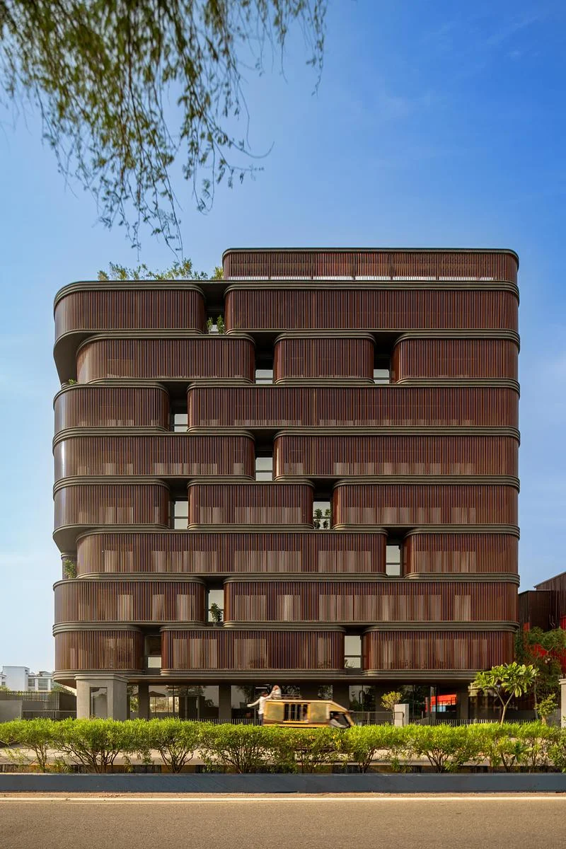The street-facing elevation framed by trees · Vinay Panjwani · via v2com
