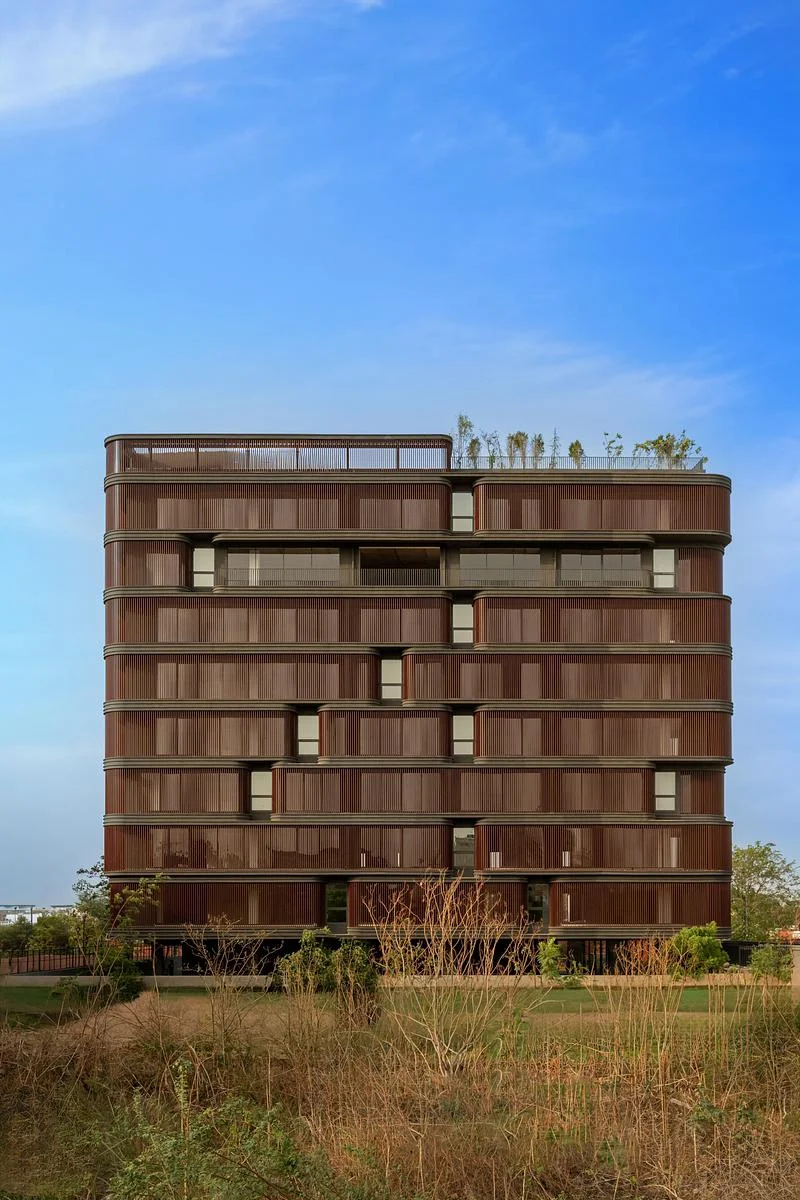 The building seen across an open foreground · Vinay Panjwani · via v2com