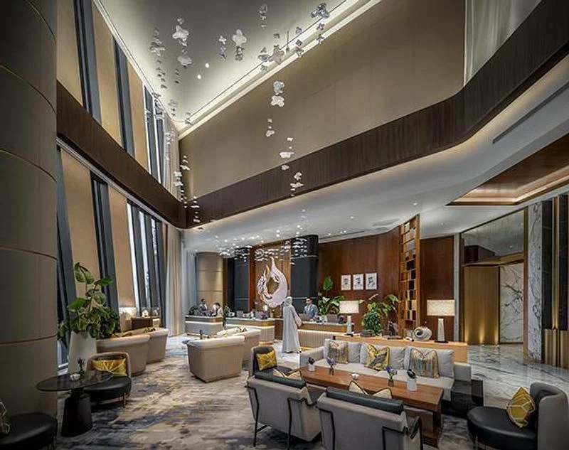 A tall hotel lounge with balconies and suspended elements · Ahmad Alnaji - SARAB · via v2com