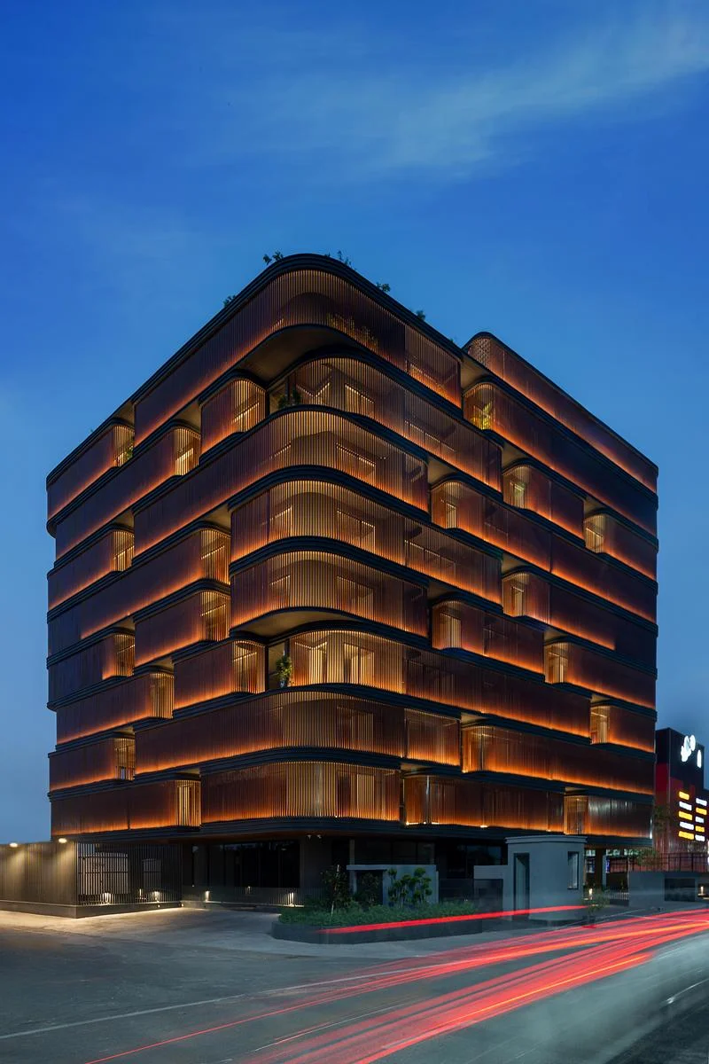 The office building illuminated at dusk · Vinay Panjwani · via v2com